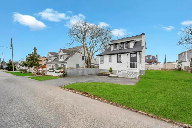 a front view of a house with garden and sitting area