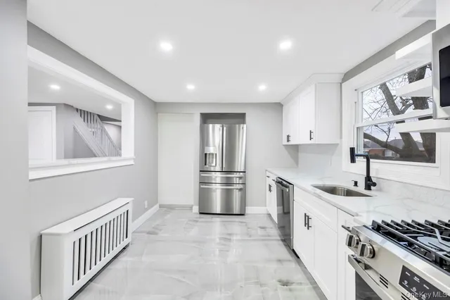 a kitchen with stainless steel appliances granite countertop a sink a stove and a refrigerator