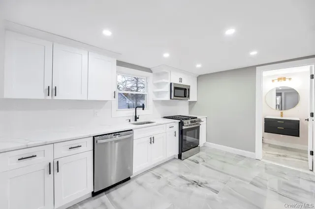 a kitchen with white cabinets and appliances