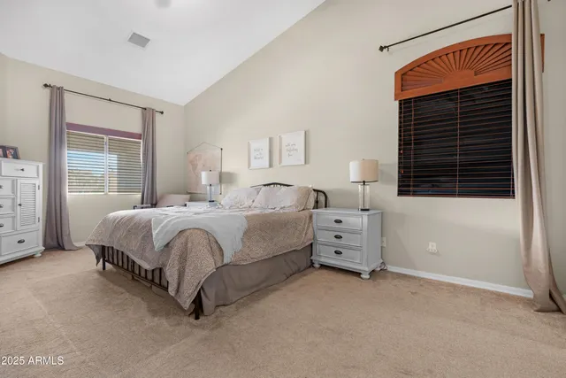 a bedroom with a bed and a lamp on dresser