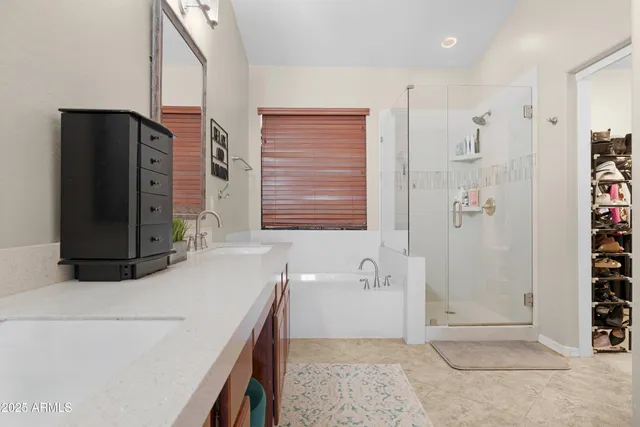 a bathroom with a double vanity sink a mirror and a bathtub