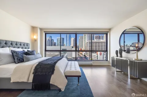 a bedroom with a balcony a bed and a large window