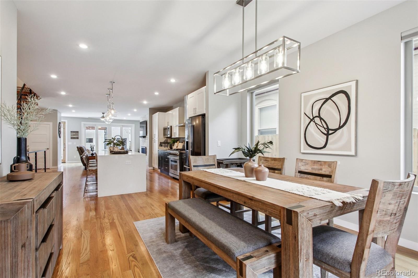 4132 Stuart Street Denver, CO 80212 - Photo 3 of 35 a view of a dining room with furniture a chandelier and wooden floor