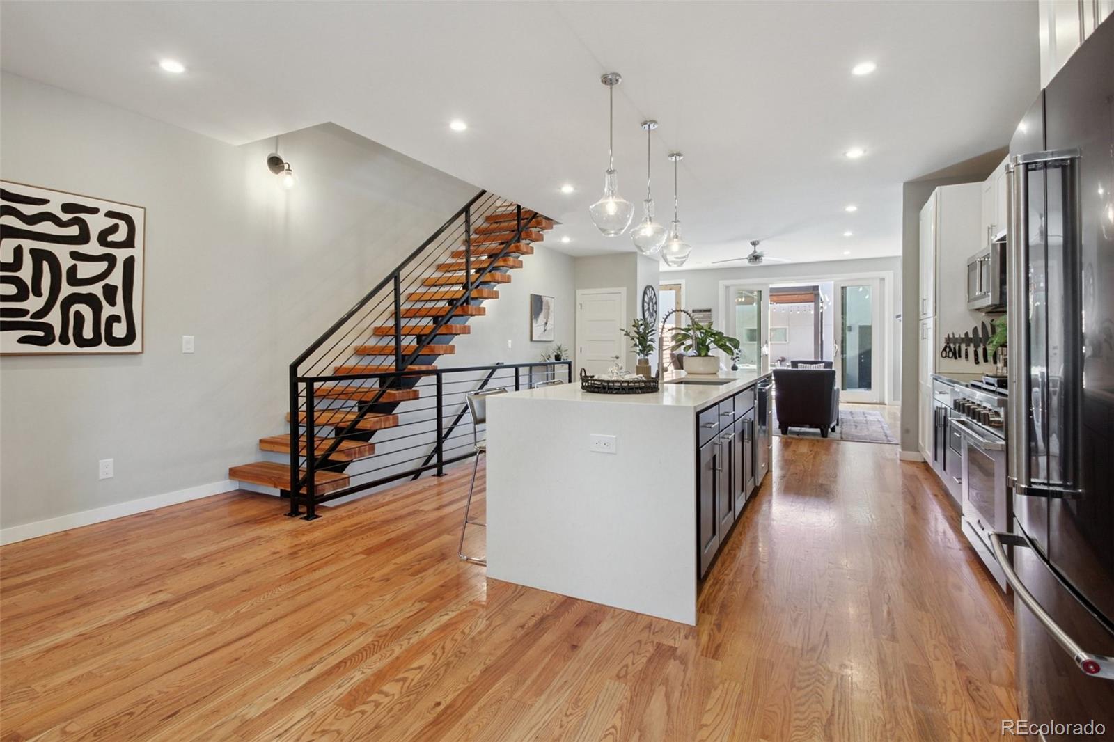 4132 Stuart Street Denver, CO 80212 - Photo 5 of 35 a view of a kitchen center island wooden floor and stainless steel appliances