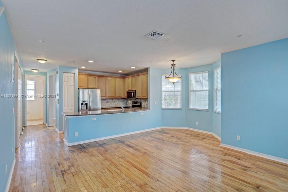 1541 Frederick Small Road, Unit 1541 Jupiter, FL 33458 - Photo 19 of 56 a view of a kitchen with kitchen island wooden floor and a window