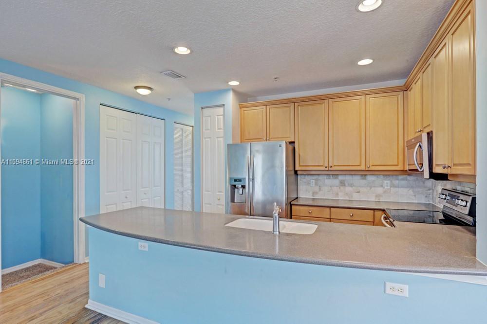 1541 Frederick Small Road, Unit 1541 Jupiter, FL 33458 - Photo 21 of 56 a kitchen with stainless steel appliances granite countertop a sink and a refrigerator
