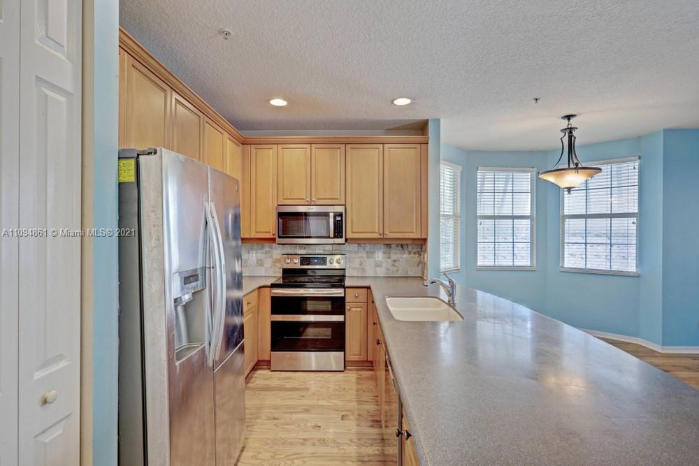 1541 Frederick Small Road, Unit 1541 Jupiter, FL 33458 - Photo 23 of 56 a kitchen with stainless steel appliances a refrigerator and a stove top oven