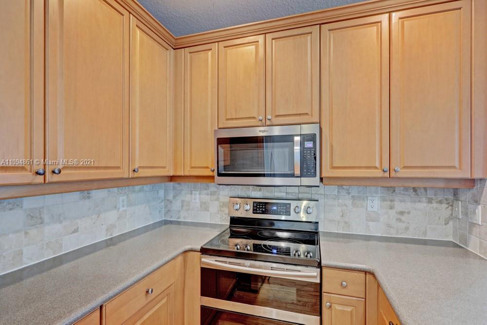 1541 Frederick Small Road, Unit 1541 Jupiter, FL 33458 - Photo 24 of 56 a kitchen with granite countertop white cabinets and stainless steel appliances