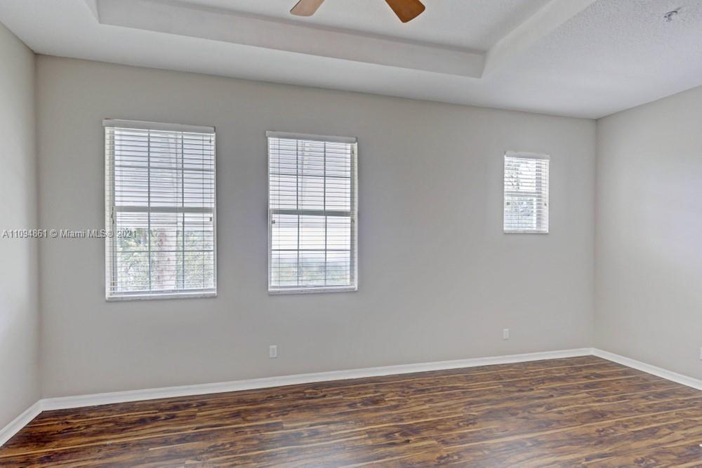1541 Frederick Small Road, Unit 1541 Jupiter, FL 33458 - Photo 43 of 56 an empty room with wooden floor and windows