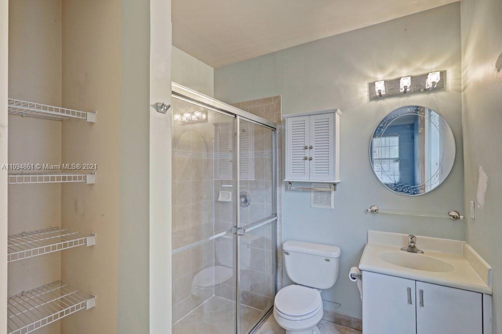 1541 Frederick Small Road, Unit 1541 Jupiter, FL 33458 - Photo 9 of 56 a bathroom with a toilet a sink a vanity and mirror