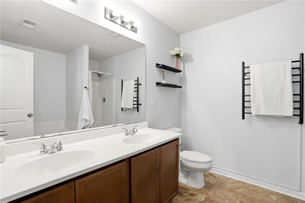 244 Sidney Lanier Avenue Athens, GA 30607 - Photo 17 of 32 a bathroom with a double vanity sink toilet and a mirror