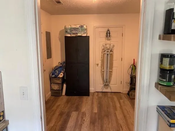 a view of a bedroom with wooden floor and a flat screen tv