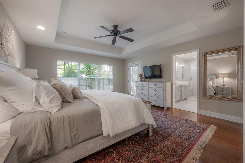 3108 West Villa Rosa Street Tampa, FL 33611 - Photo 23 of 58 a bedroom with a large bed a flat tv screen and a fireplace