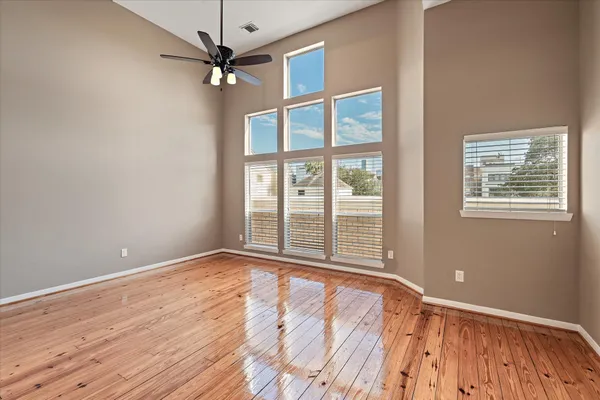 a view of an empty room with a window and wooden floor