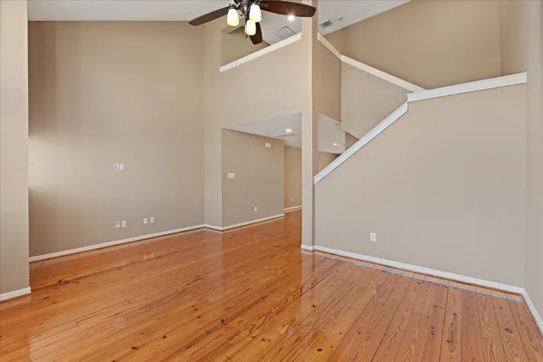 a view of an empty room with wooden floor