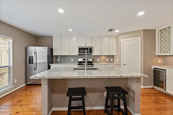 a kitchen with stainless steel appliances granite countertop a sink refrigerator and cabinets