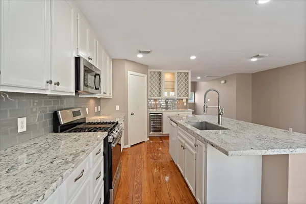 a kitchen with stainless steel appliances granite countertop a sink stove and cabinets