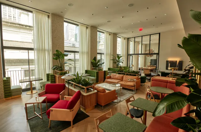 a living room with furniture a rug and a floor to ceiling window