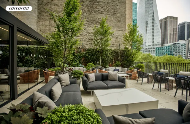 a living room with furniture large windows and wooden floor