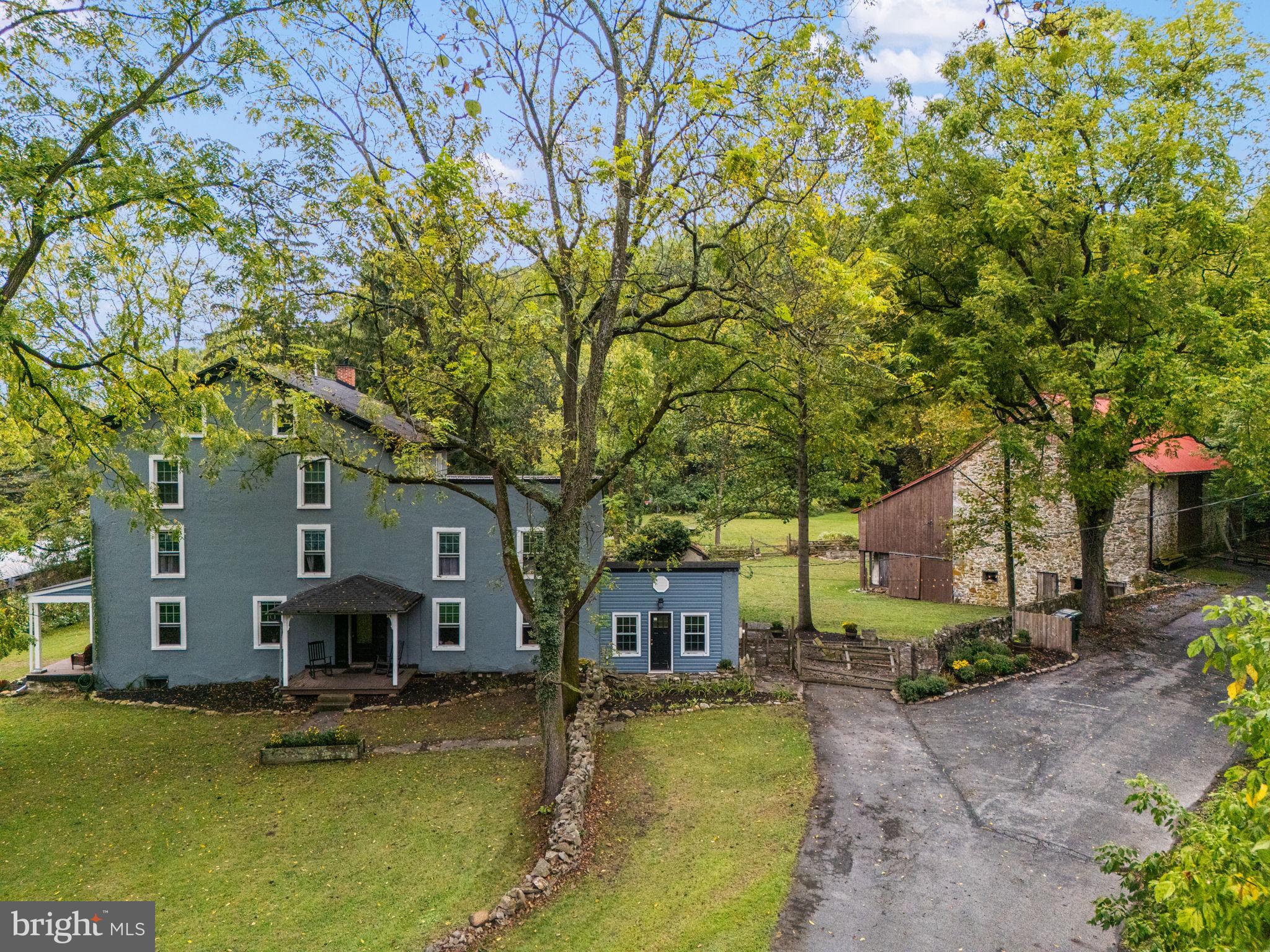 4701 Edges Mill Road Downingtown, PA 19335 - Photo 12 of 55 a front view of a house with a garden and trees