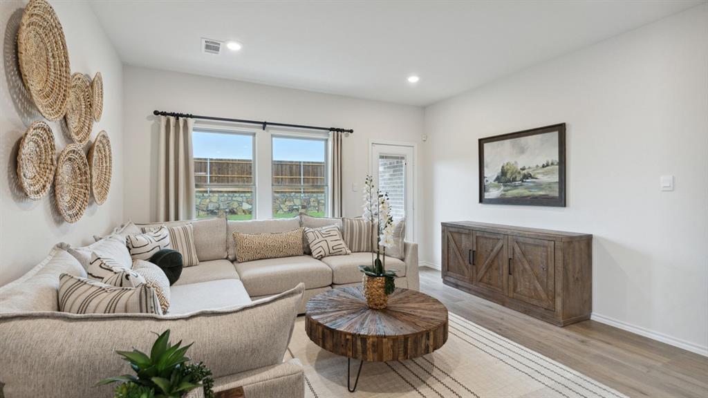 140 Pheasant Run Road Terrell, TX 75160 - Photo 12 of 26 Spacious living area featuring light wood-finish flooring, recessed lighting, and large windows with privacy fencing visible