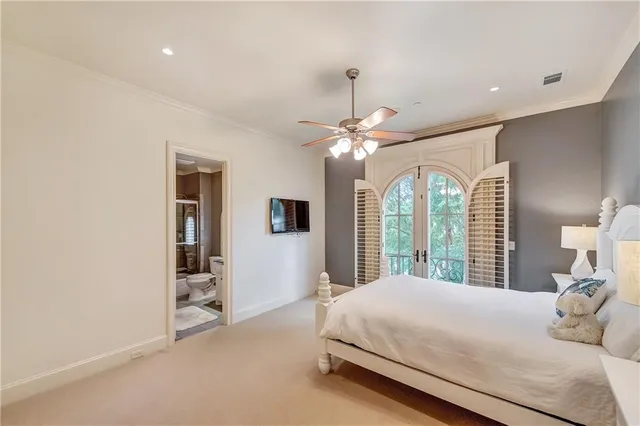 a bedroom with a large bed and a chandelier