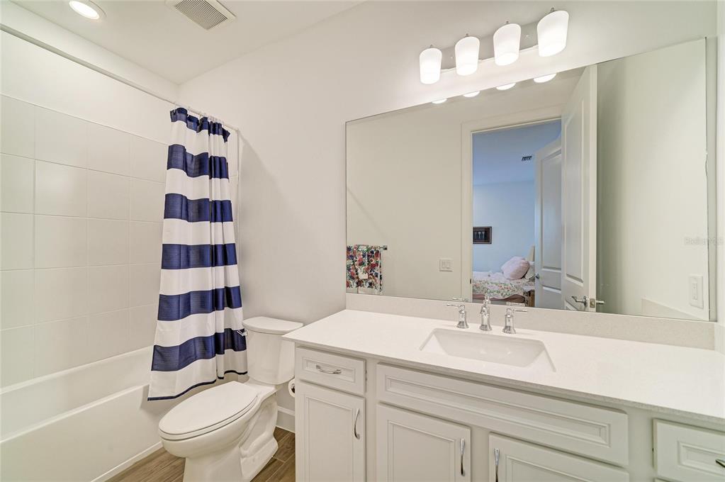 16341 Hidden Oak Loop Lakewood Ranch, FL 34211 - Photo 33 of 76 a bathroom with a sink a toilet a mirror and shower