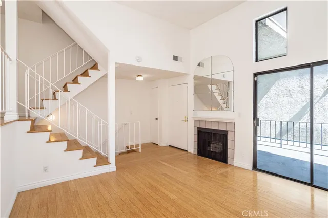 a view of an entryway with wooden floor and a fireplace