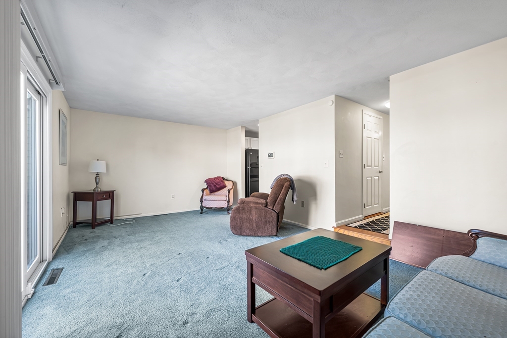 176 Patrick Road, Unit 176 Tewksbury, MA 01876 - Photo 12 of 42 a living room with furniture and a window