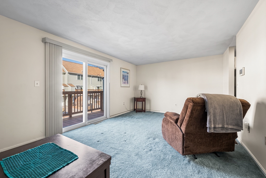 176 Patrick Road, Unit 176 Tewksbury, MA 01876 - Photo 15 of 42 a living room with furniture and a window