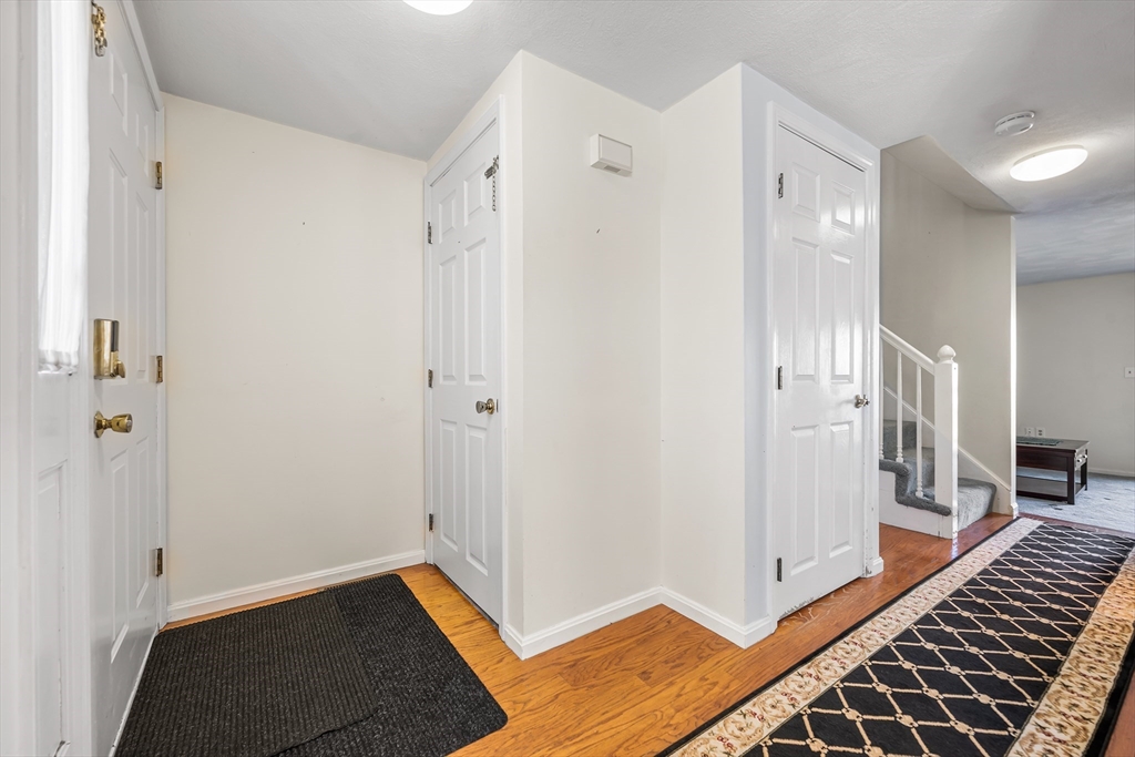 176 Patrick Road, Unit 176 Tewksbury, MA 01876 - Photo 2 of 42 a view of a hallway with wooden floor and staircase