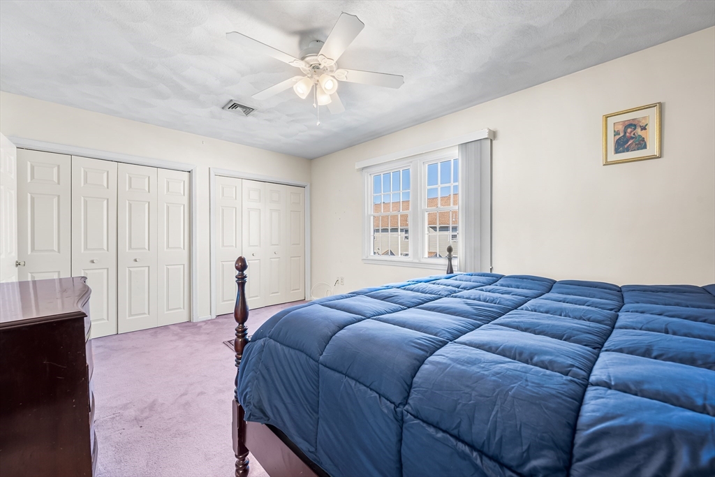 176 Patrick Road, Unit 176 Tewksbury, MA 01876 - Photo 23 of 42 a spacious bedroom with a bed and a window