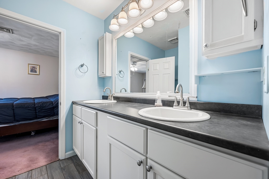 176 Patrick Road, Unit 176 Tewksbury, MA 01876 - Photo 24 of 42 a en suite bathroom with a double vanity sink and a mirror