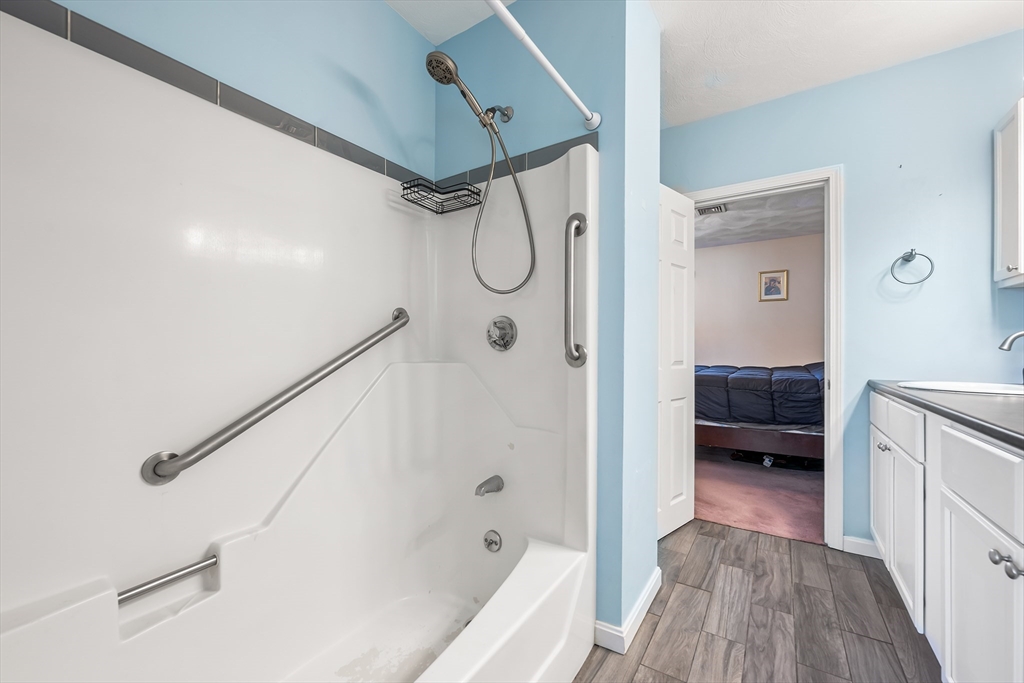 176 Patrick Road, Unit 176 Tewksbury, MA 01876 - Photo 25 of 42 a bathroom with a glass shower door