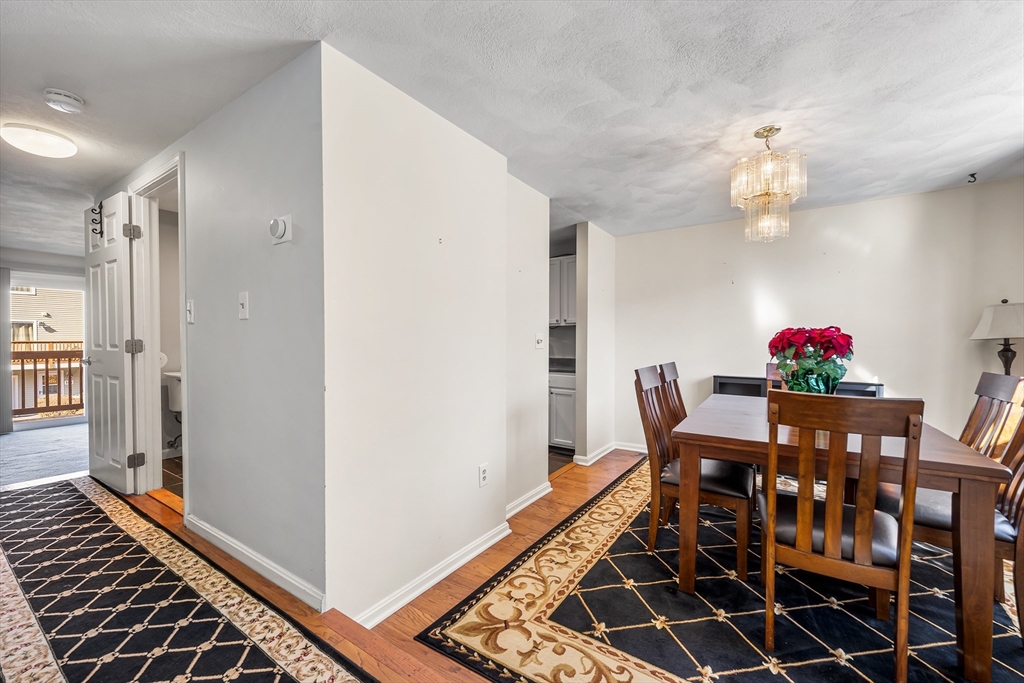 176 Patrick Road, Unit 176 Tewksbury, MA 01876 - Photo 3 of 42 a view of a dining room with furniture and wooden floor