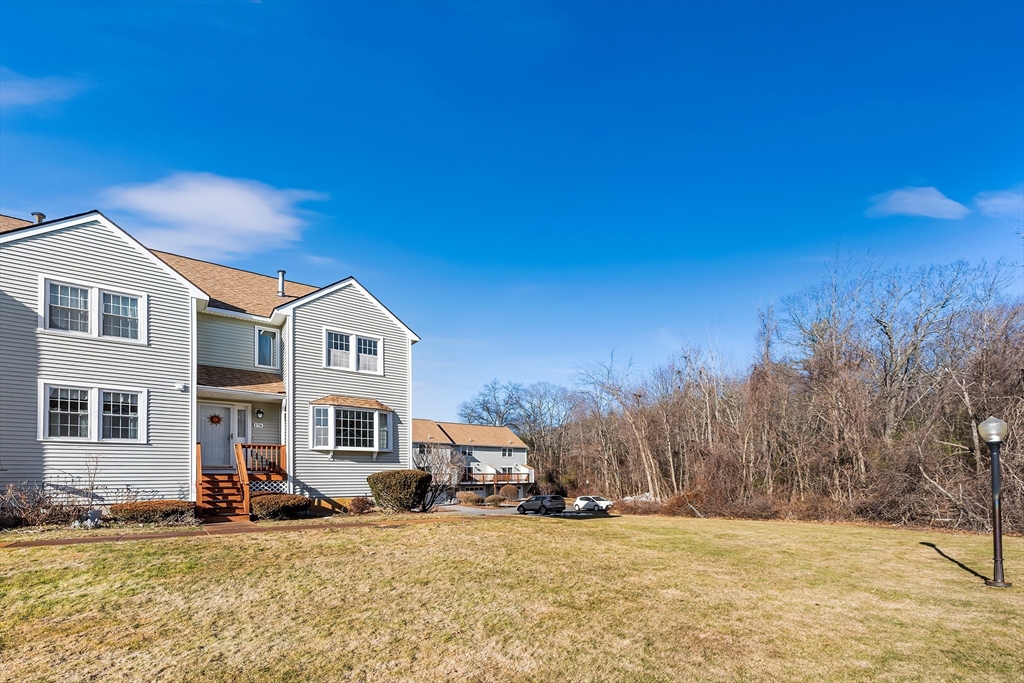 176 Patrick Road, Unit 176 Tewksbury, MA 01876 - Photo 34 of 42 a front view of a house with a yard