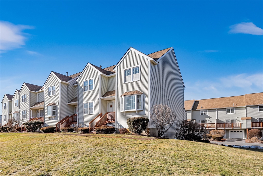 176 Patrick Road, Unit 176 Tewksbury, MA 01876 - Photo 35 of 42 a view of a building with a yard
