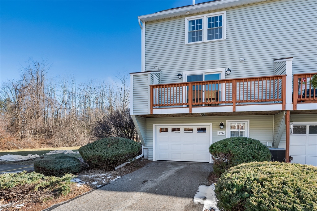 176 Patrick Road, Unit 176 Tewksbury, MA 01876 - Photo 38 of 42 a front view of a house with a yard and garage