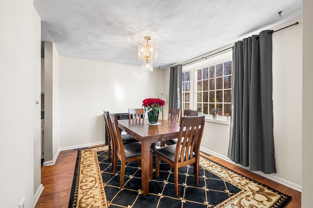 176 Patrick Road, Unit 176 Tewksbury, MA 01876 - Photo 4 of 42 a view of a dining room with furniture window and wooden floor