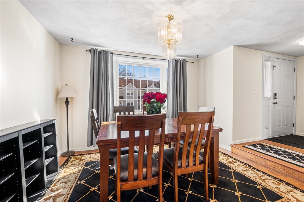 176 Patrick Road, Unit 176 Tewksbury, MA 01876 - Photo 5 of 42 a view of a dining room with furniture wooden floor and chandelier