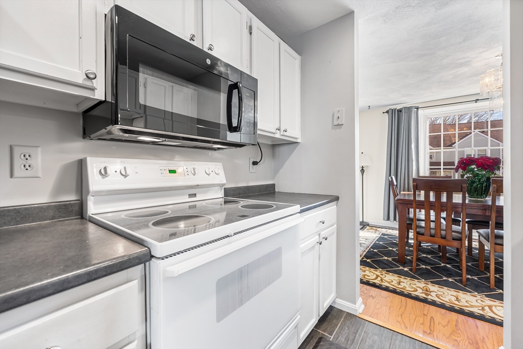 176 Patrick Road, Unit 176 Tewksbury, MA 01876 - Photo 8 of 42 a kitchen with a stove and a microwave