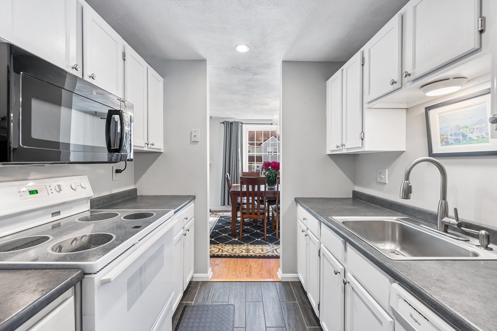 176 Patrick Road, Unit 176 Tewksbury, MA 01876 - Photo 9 of 42 a kitchen that has a sink and a stove
