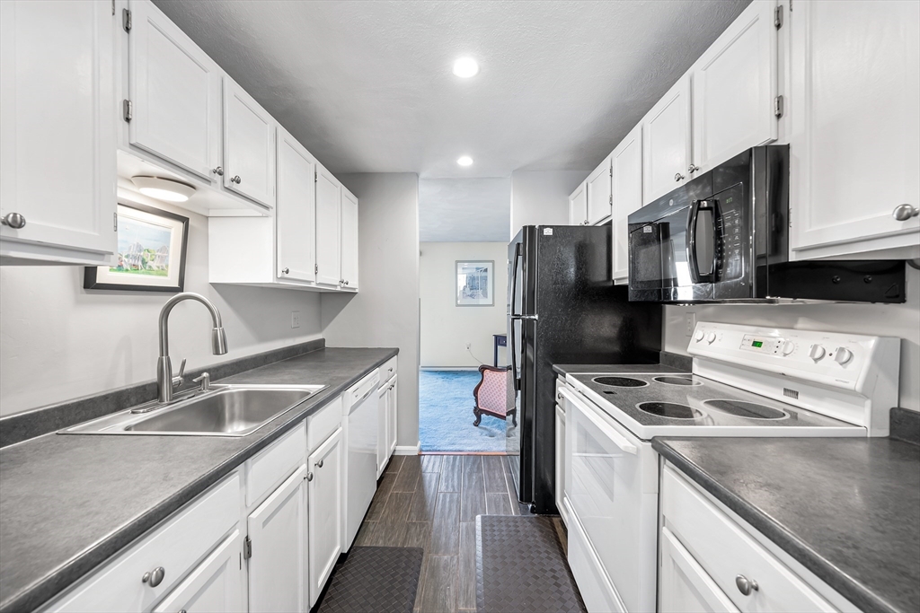 176 Patrick Road, Unit 176 Tewksbury, MA 01876 - Photo 10 of 42 a kitchen with stainless steel appliances a sink stove and refrigerator