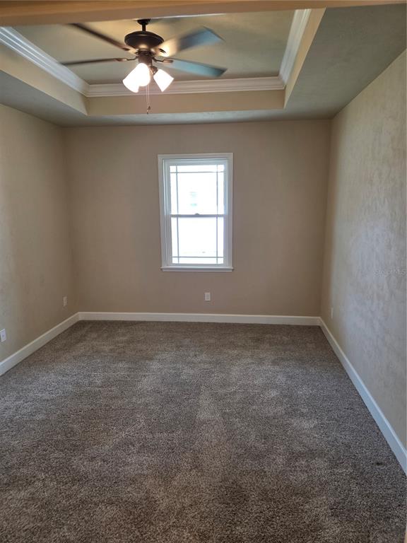 24313 Southwest 17th Lane Newberry, FL 32669 - Photo 8 of 15 an empty room with a chandelier fan and windows