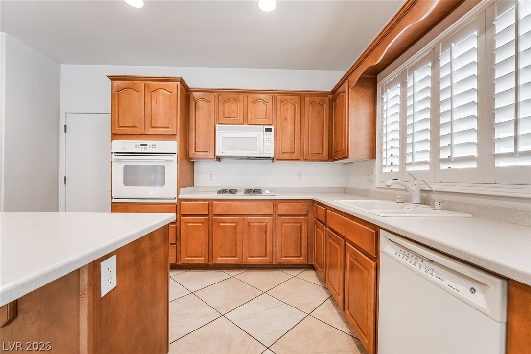 3033 Hartsville Road Henderson, NV 89052 - Photo 19 of 41 A well-appointed kitchen features ample cabinetry, an island, and a sink beneath a window with clean white shutters.