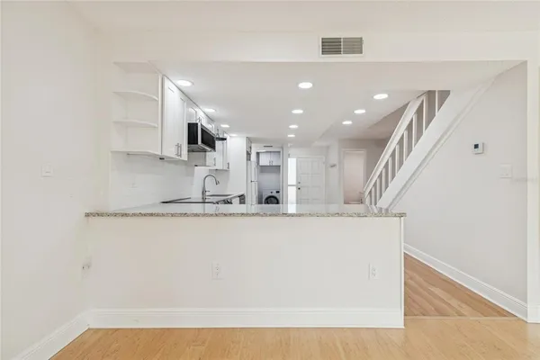 a view of staircase with wooden floor and white walls