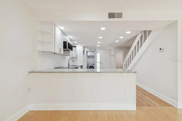 a view of staircase with wooden floor and white walls