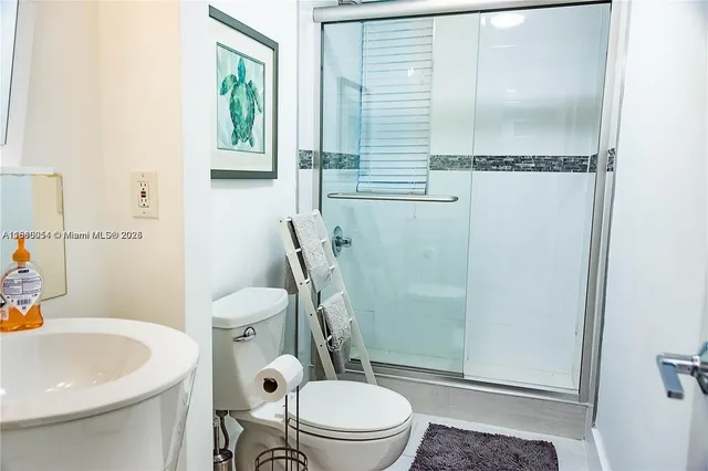 a white toilet sitting next to a bathroom sink