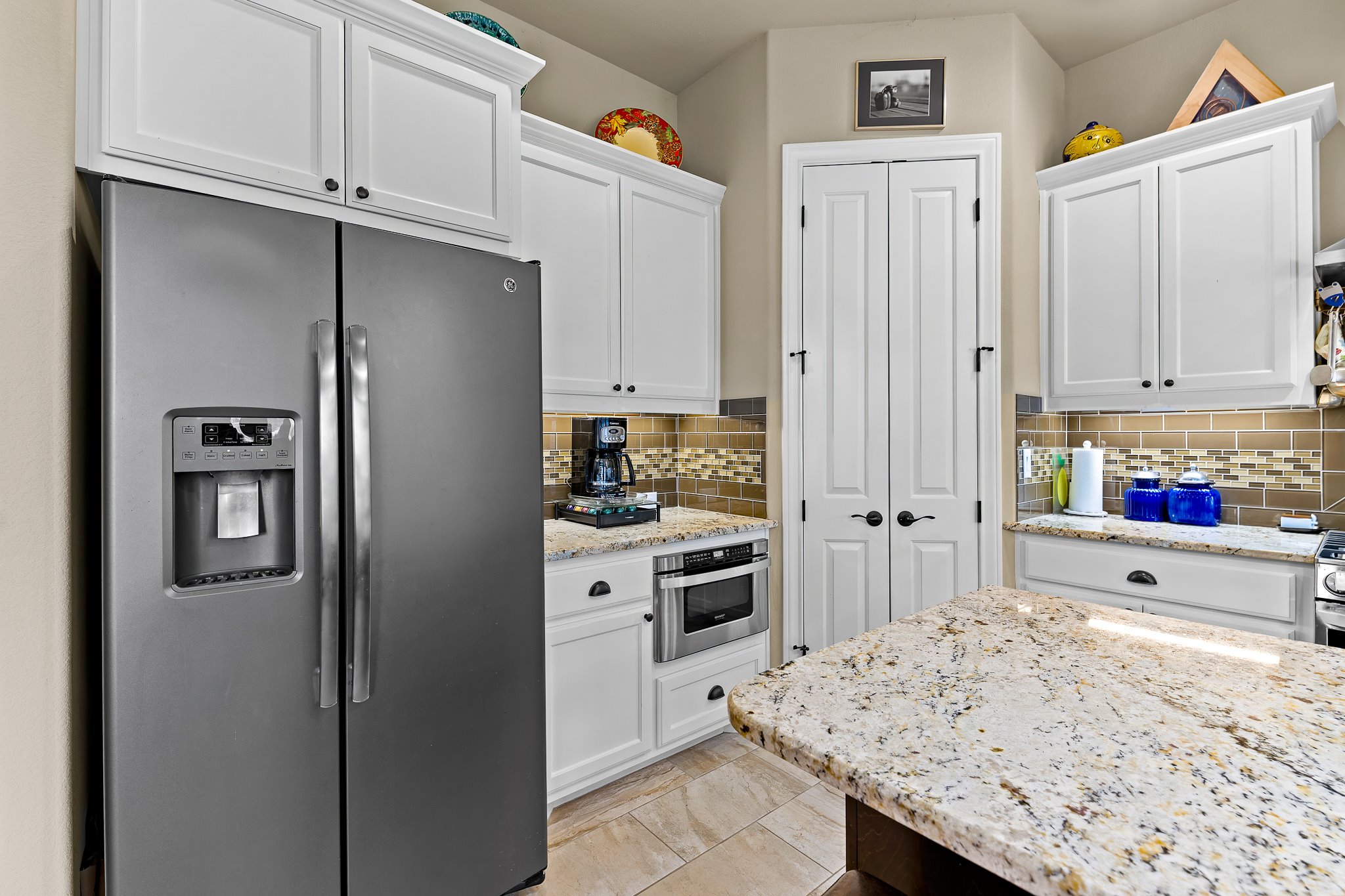 204 Venture Boulevard South Point Venture, TX 78645 - Photo 16 of 40 a kitchen with granite countertop cabinets and refrigerator