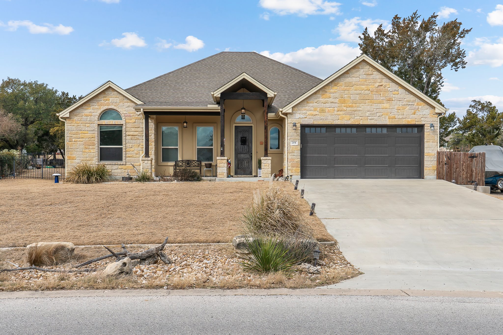 204 Venture Boulevard South Point Venture, TX 78645 - Photo 2 of 40 a view of a white house with large trees next to a yard